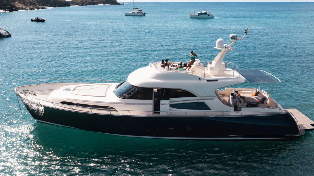 Mochi 74 motor yacht in turquoise waters with guests on board